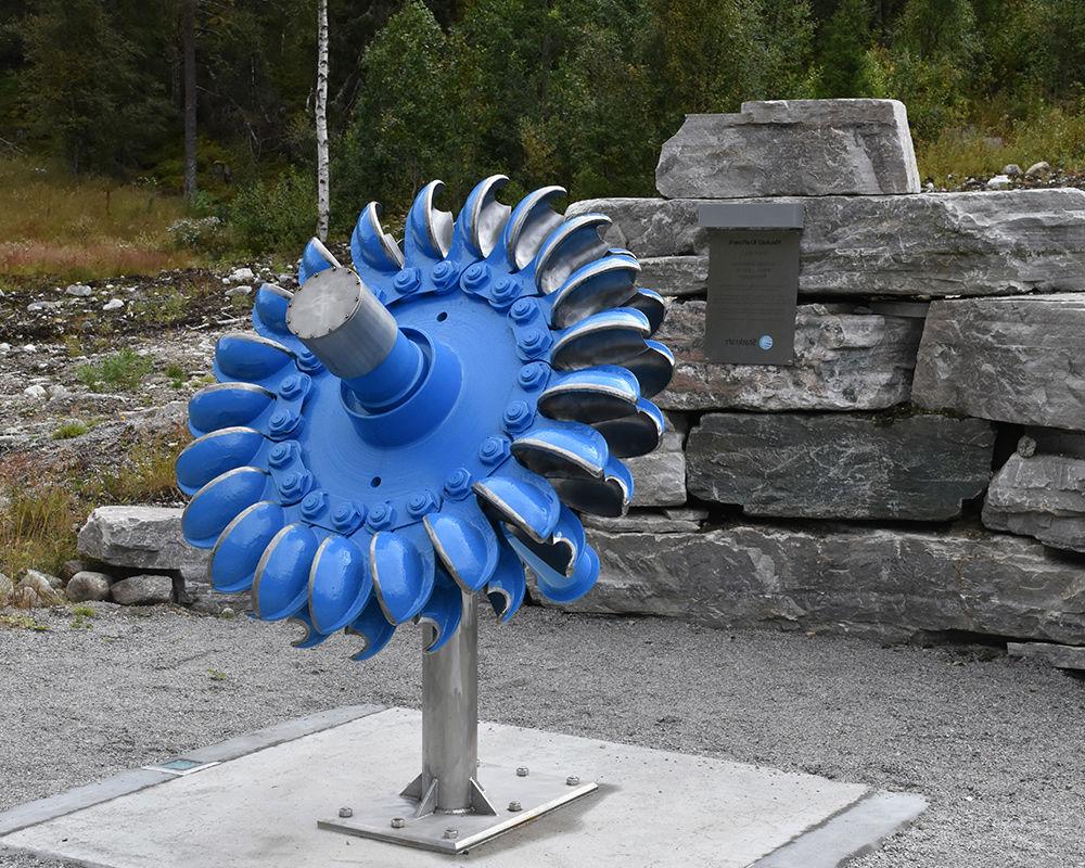 An old turbine runner and a commemorative plaque celebrate over 50 years of operation for the old 豪克利电厂